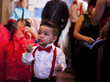 young child walking around in formal wear for his sisters quinceanera