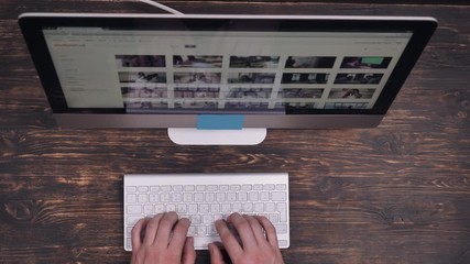 Aufkleber - Close up details male hands typing on keyboard. Person working at wooden desk with modern display.