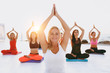 © ViDi Studio - A group of women doing yoga at sunrise near the sea