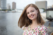 © aldarinho - Portrait of young smiling caucasian woman, with embankment area at background