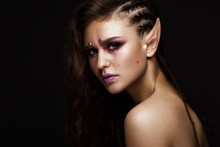 Brunette Girl With A Creative Hairstyle Braids, Art Make-up And The Elf's Ears. Beauty Face. Photo Taken In The Studio.