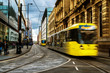 Light rail yellow tram in the city center of Manchester, UK