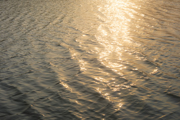 Wall Mural - View of golden sunlight reflecting on sea water in the afternoon