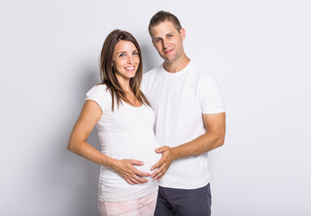 Wall Mural - caucasian couple expecting baby smiling cheerful on white