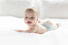 Cute Happy 7 Month Baby Girl In Diaper Lying And Playing