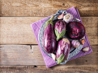 Wall Mural - Some eggplants, garlic and red onion on a bowl