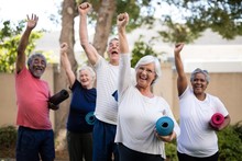 Cheerful Multi-ethnic Seniors With Exercise Mats At Park