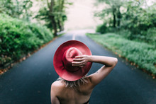 Woman Wearing Red Hat In The Middle Of The Road