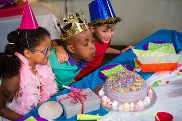 Wall Mural - Boy blowing candles on cake