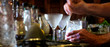 Bartender stirs a cocktail with motion blur. Selective focus on the frosty glasses. View from behind the bar.