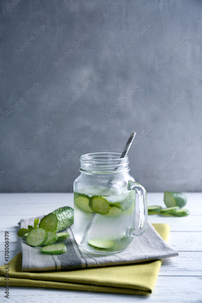 Delicious refreshing water with mint and cucumber in mason jar on table