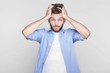 © Yulia - Desperate stressed young Caucasian bearded man looking at camera in terror and shock, keeping mouth closed with clenched teeth, holding head, frightened while blaming hisself in making awful mistake.