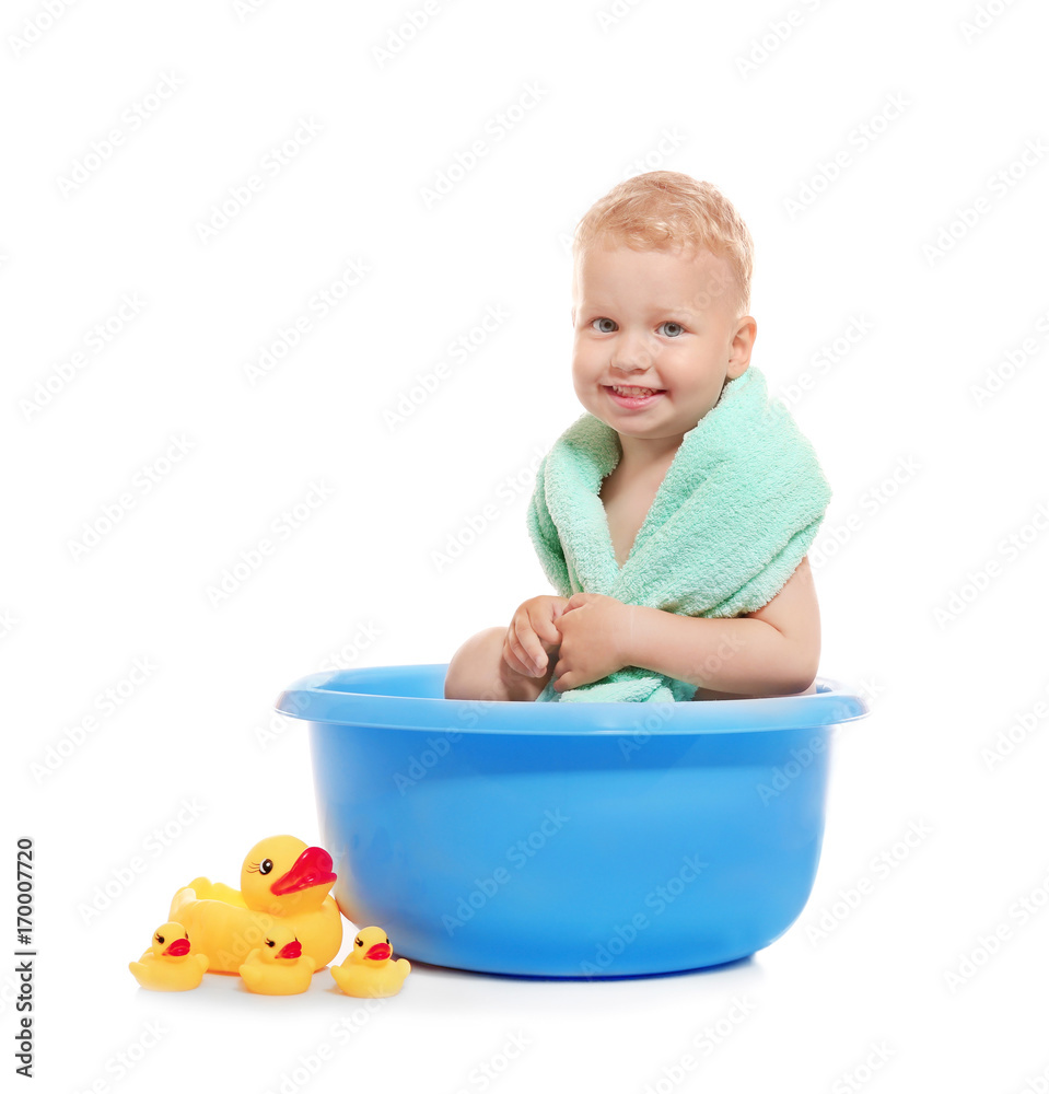 Adorable little boy sitting in plastic basin isolated on white