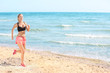 © Africa Studio - Beautiful young woman running on sea beach