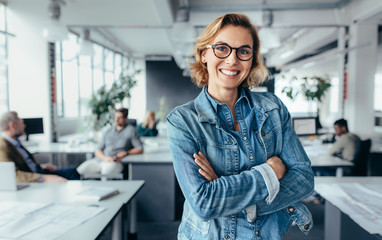 happy female designer standing in office
