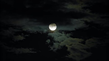 new moon and clouds in the pitchblack sky. long shot