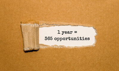 Wall Mural - The text 1 year is 365 opportunities appearing behind torn brown paper