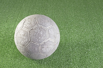 Old football on artificial turf