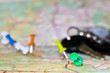 Travel destination points on a map indicated with colorful thumbtacks and shallow depth of field with space for copy. The keys to the car in the blur in the background.