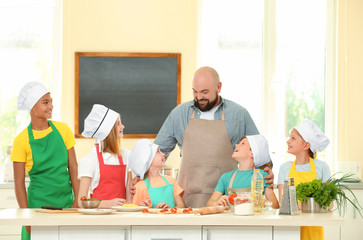 Poster - Group of children and teacher in kitchen during cooking classes