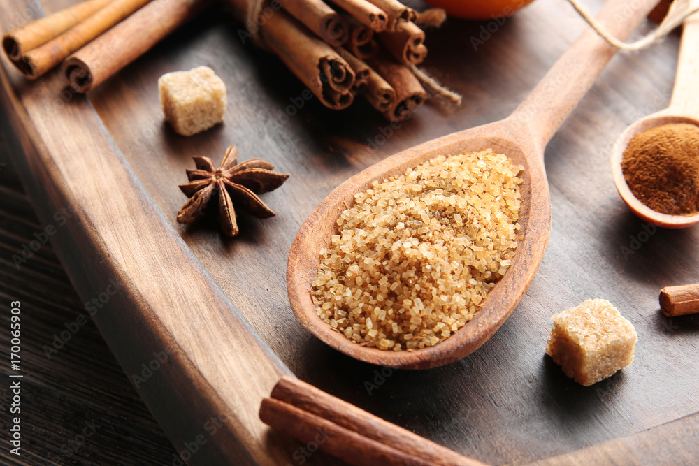 Cinnamon sugar in wooden spoon on serving board