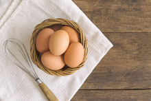 Fresh Eggs In Old Wood Basket Put On White Napkin. Prepare Fresh Chicken Eggs For Cooking Or Bakery On Wood Rustic Wood Table. Top View Or Flat Lay Of Eggs With Copy Space For Background Or Wallpaper.