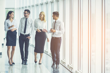 Wall Mural - The business people walk in the office hall on the sunny background