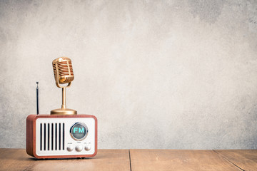 Wall Mural - FM radio receiver and golden microphone front concrete wall background. Listening music concept. Vintage old instagram style filtered photo