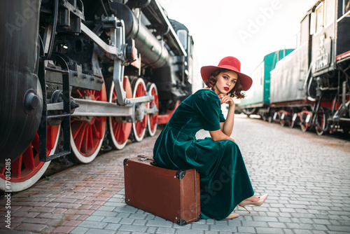 Fotografía Woman in red hat against vintage steam train