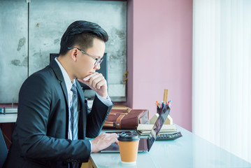 Young asian businessman working with laptop computer in office