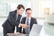 © gamelover - Young asian businessman and businesswoman discussing about work in office