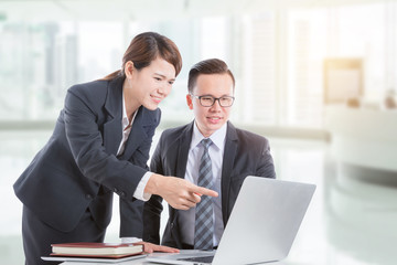 Wall Mural - Young asian businessman and businesswoman discussing about work in office