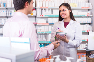 Wall Mural - Pharmacist and customer in drugstore .