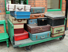 A Stack Of Vintage Cases On An Old Porters Trolley.
