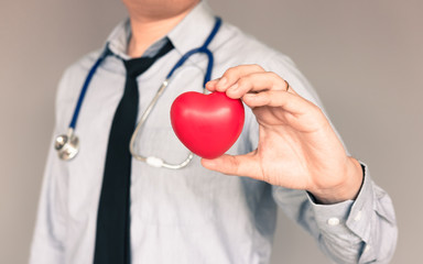 Doctor with casual wear and hand holding heart.