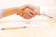 Closeup of a young man an a young woman shaking hands after signing a prenuptial agreement