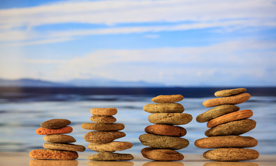 Zen stones stacks on blue sky and sea background