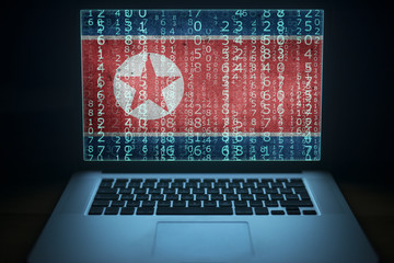 North Korea hacker. Laptop with binary computer code and Korean flag on the screen. Internet and network security.