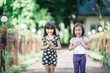 © luvvstudio - Two little girls relaxing play in the park and eat lollipops