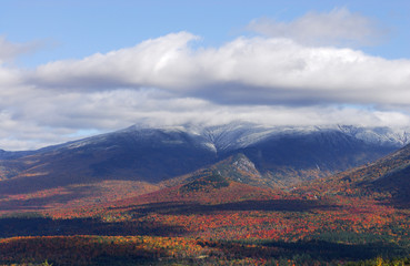 Wall Mural - autumn colorful forest and mountain peaks after snow with cloud