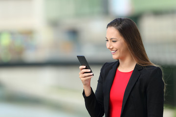 Poster - Executive girl reading messages on phone on the street