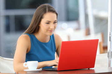 Sticker - Serious woman typing in a red laptop in a bar