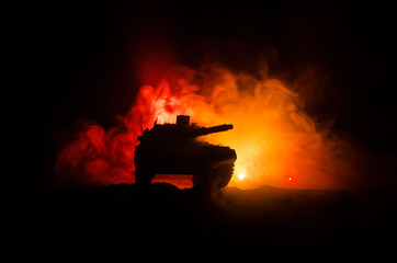 Wall Mural - War Concept. Military silhouettes fighting scene on war fog sky background, German tank in action Below Cloudy Skyline At night. Attack scene. Armored vehicles