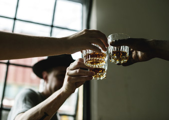 People cheers an alcohol glass together