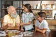 © zinkevych - Grandfather and grandchildren assembling jigsaw puzzle altogether