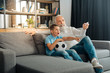 © zinkevych - Grandfather increasing volume on TV set while watching football