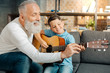 © zinkevych - Loving grandfather teaching grandson how to hold guitar