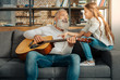 © zinkevych - Grandfather chatting with granddaughter while holding guitar