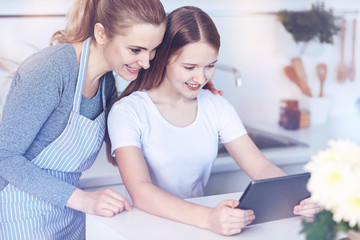 Canvas Print - Loving mom embracing her teenage daughter in kitchen