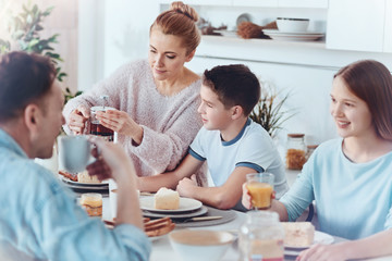 Wall Mural - Thoughtful mother taking care of family during breakfast